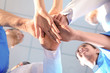 © New Africa - Young medical doctors putting hands together indoors, bottom view. Unity concept