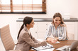 © New Africa - Female insurance agent consulting young woman in office