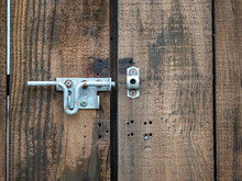 Wooden Double Door Of Entrance With An Open Metal Latch Lock