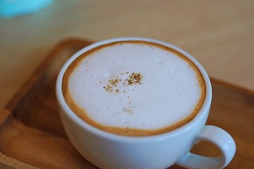 Latte coffee on wooden table closeup