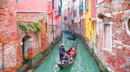 venetian-gondolier-punting-gondola-through-green-canal-waters-of-venice-italy