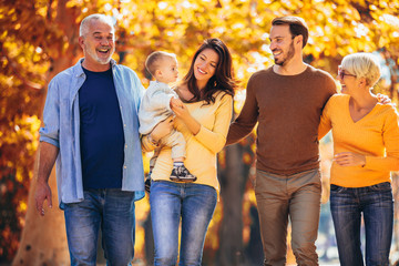 Wall Mural - Multl generation family in autumn park having fun