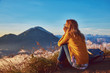 © astrosystem - Woman enjoying nice landscape and sunrise from a top of mountain Batur, Bali, Indonesia.