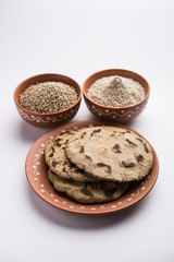 Wall Mural - Bajra (pearl millet) / sorghum grains with it's flour or powder in a bowl, selective focus