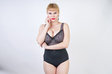 Pretty Short Hair Blonde Woman With Plus Size Body Wearing Retro Black Lingerie And Posing On White Studio Background Alone
