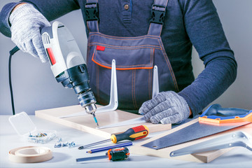 Wall Mural - Closeup portrait of male hands making furniture in carpenters workshop.