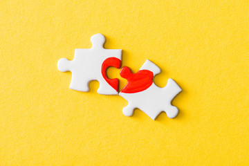 Wall Mural - top view of jigsaw puzzle pieces with drawn red heart isolated on yellow