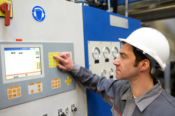 Industriearbeiter in einer modernen Fabrik - Bedienung, Steuerung und Kontrolle der Maschinen // Industrial worker in a modern factory - operation, control and monitoring of machines