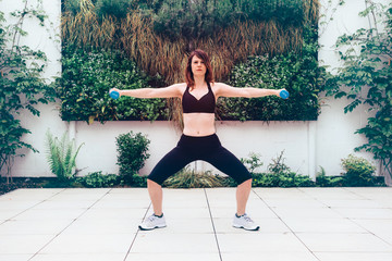 woman busy with an outdoors workout in a terrace