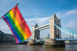 © lazyllama - Gay pride rainbow flag hanging in front of the London skyline at Tower Bridge on a bright sunny summer day along the River Thames