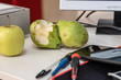 Fresh fruit on the office table. Pear bitten.
