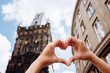 © Stanislav - Girl showing heart shape love symbol over cityscape. Woman making heart shape with hands. Sights of Prague, Czech Republic