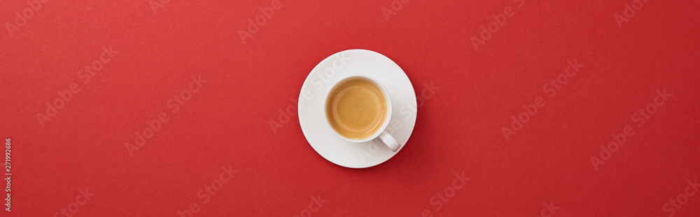 top view of white cup with fresh coffee on saucer on red background, panoramic shot - obrazy, fototapety, plakaty 