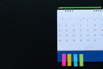 close up of calendar on the black table background, planning for business meeting or travel planning concept