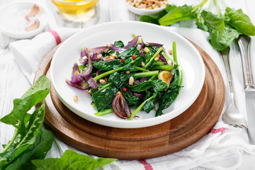 Wall Mural - Garnish steamed spinach with fried onion and nuts.