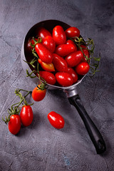 Wall Mural - fresh and ripe tomatoes in the old colander on a rustic gray background