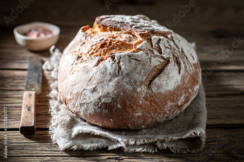 Cuadros en Lienzo Fresh loaf of bread with salt on wooden table