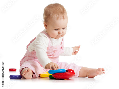 Infant baby plays with educational toy. Isolated on white background