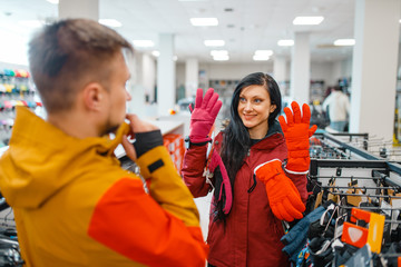 Wall Mural - Couple choosing gloves for ski or snowboarding