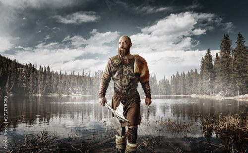 Handsome viking with axes standing at the lake Wallpaper Mural