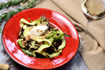 Canvas Print - salad with salmon, avocado and capers on a red plate