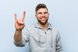 © Asier - Young handsome fitness man showing a horns gesture as a revolution concept.