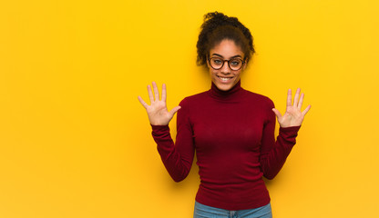 Wall Mural - Young black african american girl with blue eyes showing number ten