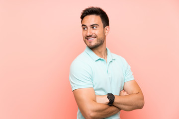 Handsome young man over isolated background with arms crossed and happy