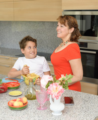 Happy mother and son preparing lunch with a mortar