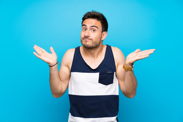 Handsome young man over isolated background making doubts gesture