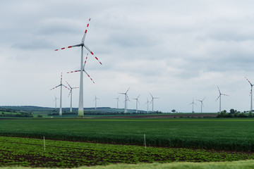 Wind turbine on green fields in summertime.  Natural wind power plants and sustainable eco-friendly energy resources 