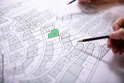 Cuadros en Lienzo Human Hand Holding Pencil Over Cadastre Map