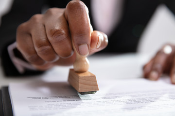 Businesswoman Putting Stamp On Documents