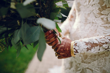 Wall Mural - Beautiful bride in a white dress. Woman with flowers. Lady with mehendi on her hands