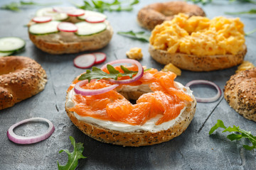 Wall Mural - Healthy Bagels breakfast sandwich with salmon, scrambled eggs, vegetables and cream cheese