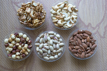 Wall Mural - Healthy food. Nuts mix assortment on stone texture top view. Collection of different legumes for background image close up nuts, pistachios, almond, cashew nuts, peanut, walnut. image