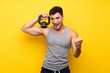 © luismolinero - Handsome sport man over isolated background with kettlebell