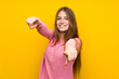 © luismolinero - Young woman with long hair over isolated yellow wall points finger at you while smiling