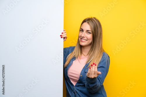 Young woman holding an empty placard presenting and inviting to come Canvas