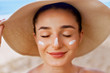 © verona_studio - Beautiful woman applying cream sunscreen on tanned face. Sunscreen. Skin and body care. The girl uses a sunscreen for her skin. Portrait of a female holding suntan lotion and moisturizing sunscreen.