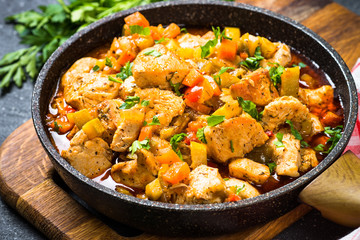 Chicken stew with vegetables in skillet.