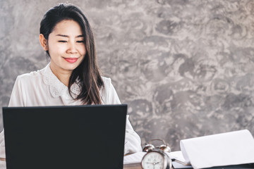 Wall Mural - beautiful Asian business woman sitting at office desk happy working on computer 