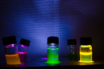 multiple colourful close up photochemical reaction in glass vial under uv light in a dark chemistry 