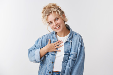 Wall Mural - Flattered cute tender feminine young woman blond curly bun blue eyes press palm chest grateful tilting head smiling pleased appreciating nice compliment, thanking help, look grateful thankful