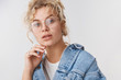 © Cookie Studio - Close-up elegant good-looking fashionable blond blue-eyed blogger wear transparent glasses denim jacket touching chin thoughtful look camera intrigued, interested, standing white background