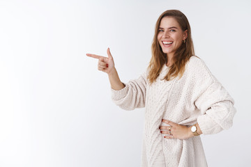 Wall Mural - Girl laughing smiling happily standing profile pointing index fingers side turning camera giggling grinning joyfully showing awesome promo advertisement, glad share with you, white background