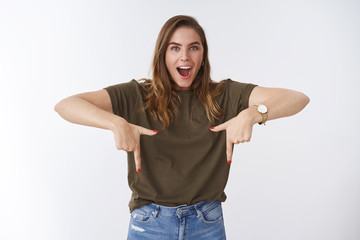 Wall Mural - Impressed overwhelmed attractive adolescent 25s woman wearing casual outfit drop jaw amused astonished pointing index fingers bottom side down, indicating incredible sale advertisement copy space