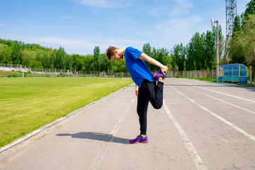  concentrated male athlete outdoor stretching his body in sportswear  doing healthy practises