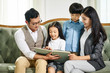 © imtmphoto - asian family with two children reading book together
