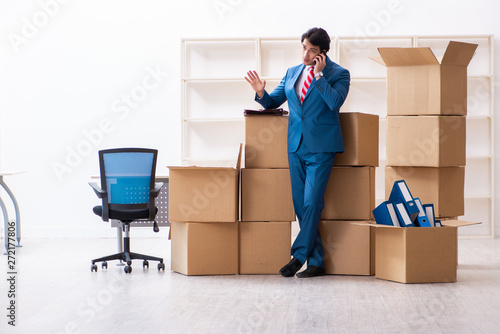 фотография  Young handsome businessman moving to new workplace